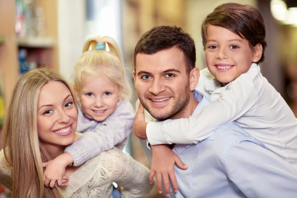 Smiling family of four together, representing dependants joining a Skilled Worker visa holder in the UK.