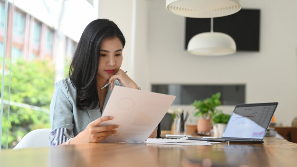 A professional reviewing UK visa documents at a desk, representing Skilled Worker visa holders planning their route to settlement and ILR in 2025.