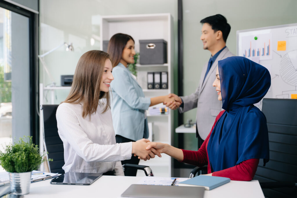 Two professionals shaking hands in an office, symbolising a successful job change under the UK Skilled Worker visa rules in 2025.