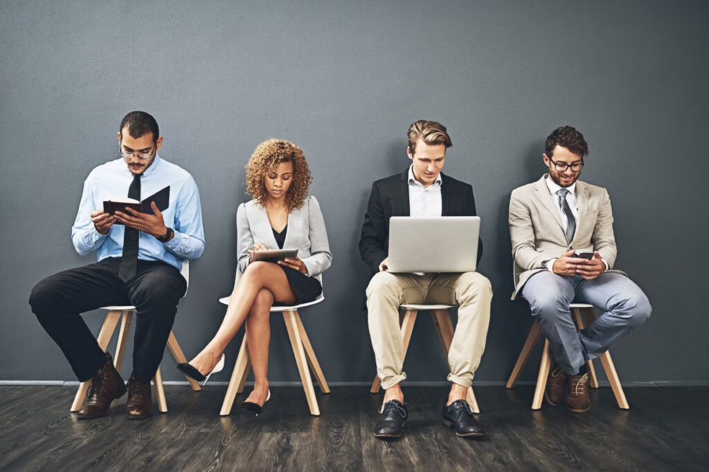 A professional recruiter speaking with an applicant across a desk, with documents and a laptop visible, representing support for Skilled Worker visa sponsorship.